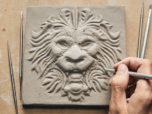 Artist Carving Lion Tile Sculpture in Clay