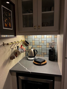 Small kitchenette with coffee-making equipment and custom craftsman tiled backsplash